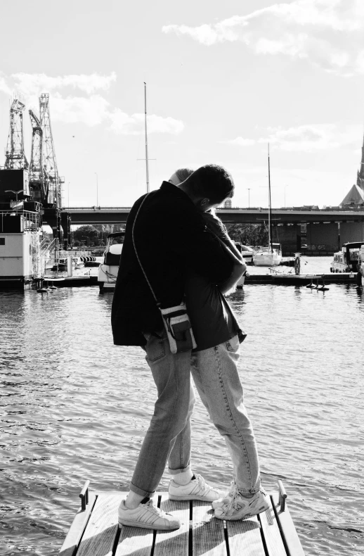 two people are standing on top of a boat dock