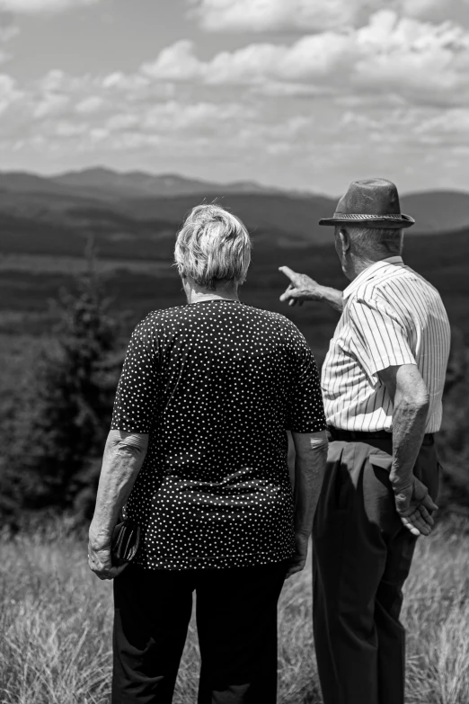 an older couple who are pointing towards the distance