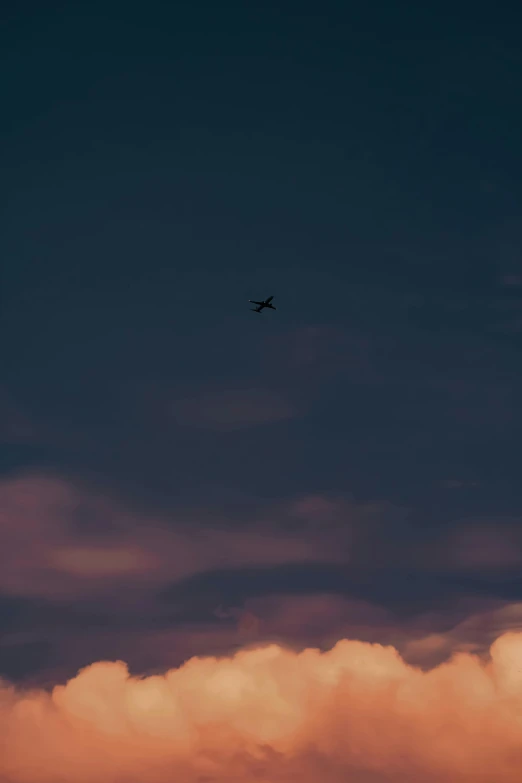 the airplane is flying high above the clouds