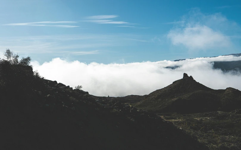 a large mountain covered in clouds with the tops obscured by them