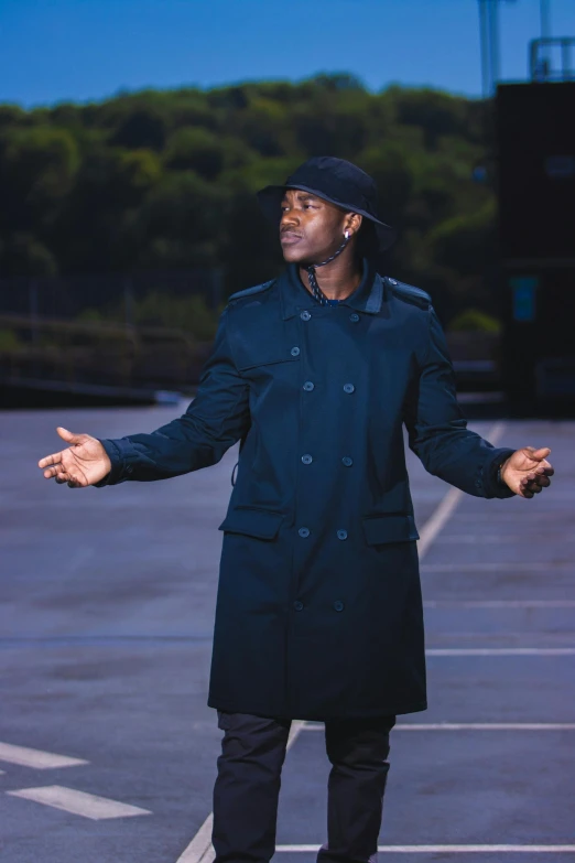 a man wearing black standing on top of a parking lot