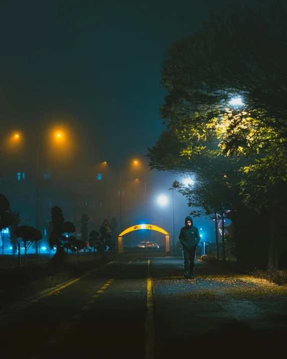 a man standing alone under street lights at night