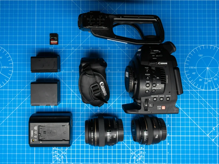 a video camera, lens, and other accessories sitting on a blue board