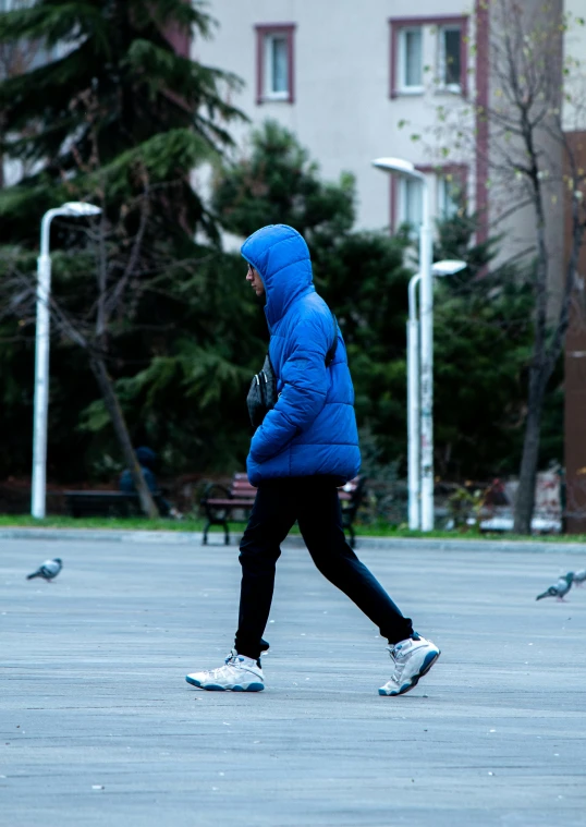a young man is walking while birds are flying around