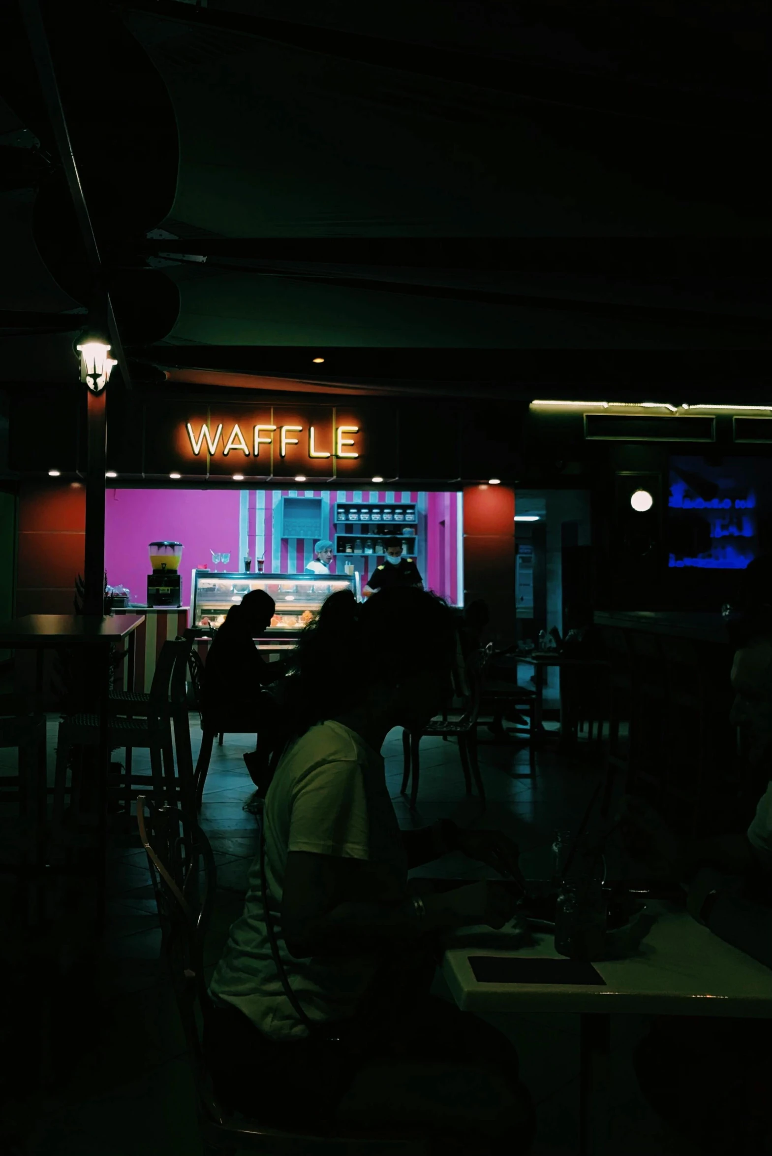 two people sitting at a table eating some food