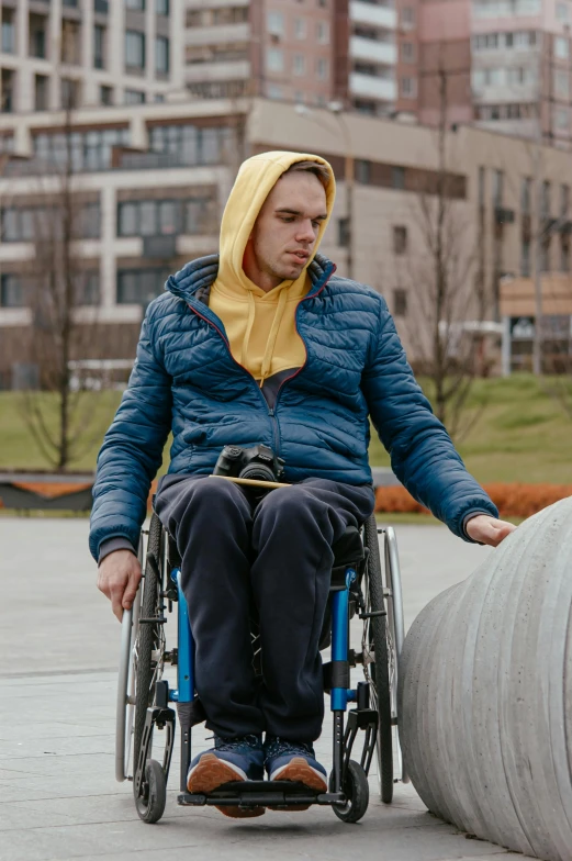 the man is sitting on his wheelchair outside