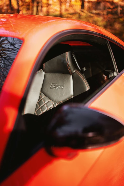 the side view mirror of an orange sports car