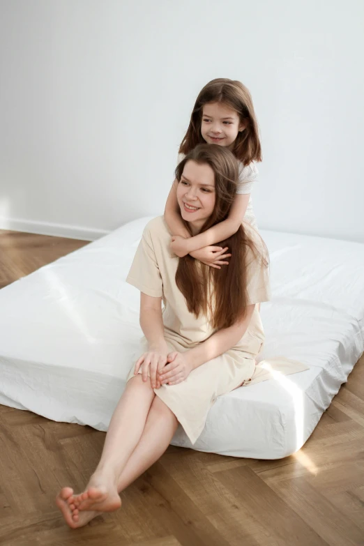 the mother smiles while sitting on her daughter's back