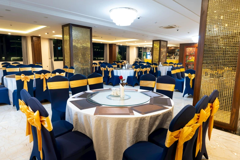 the banquet hall set up for dinner with blue chairs