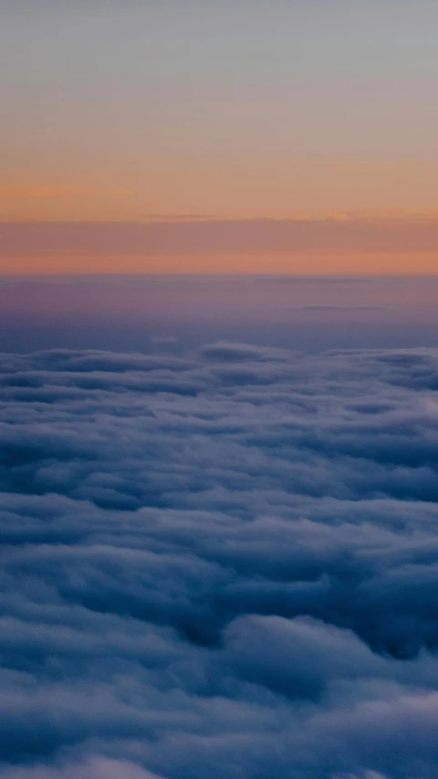 a view of the top of an airplane flying above the clouds