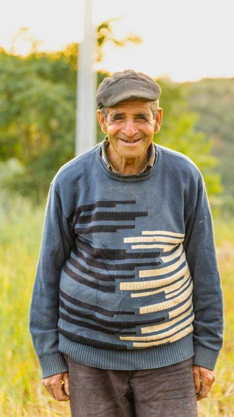 an older man is standing in the grass