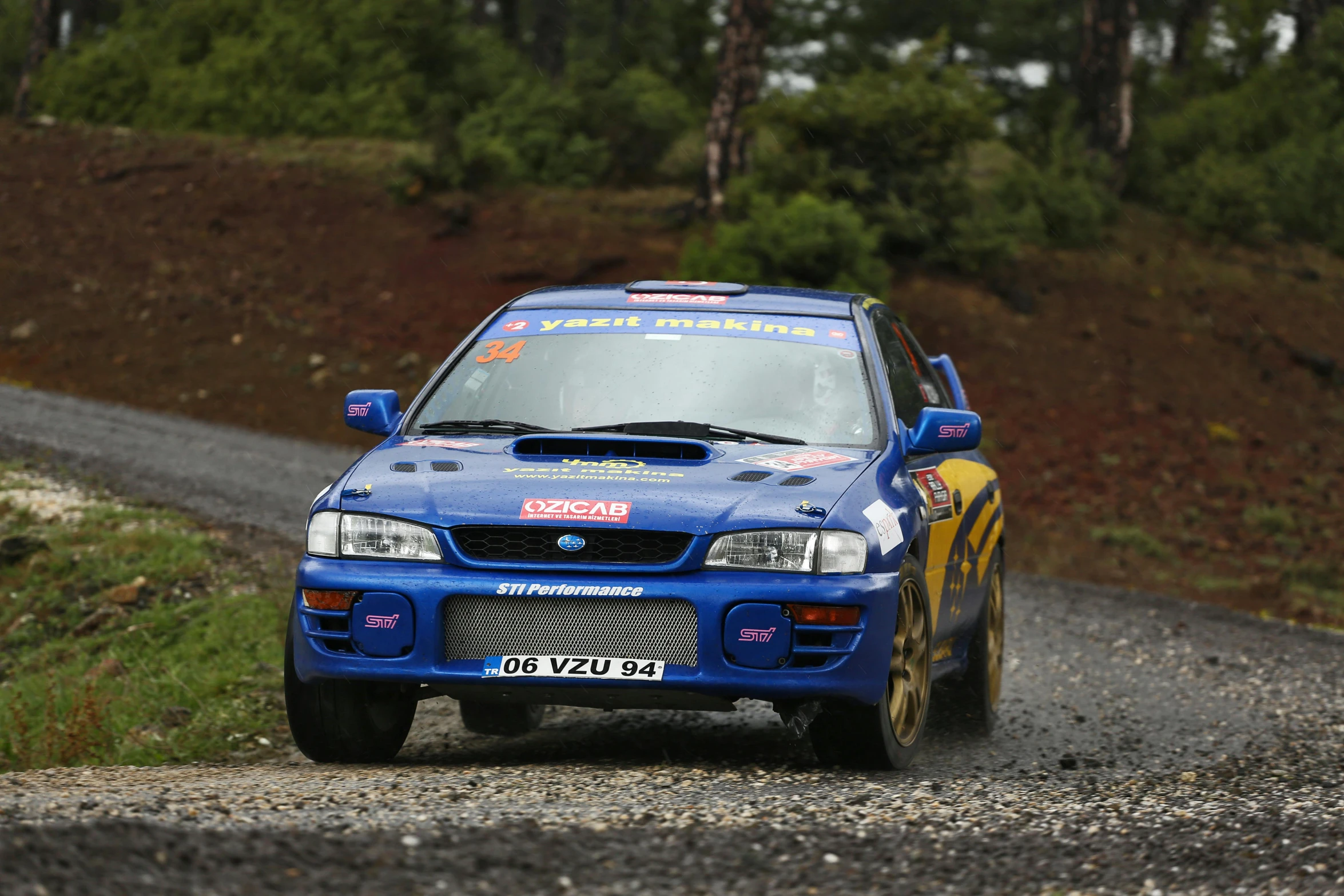 the subarub rally car is driving around a bend