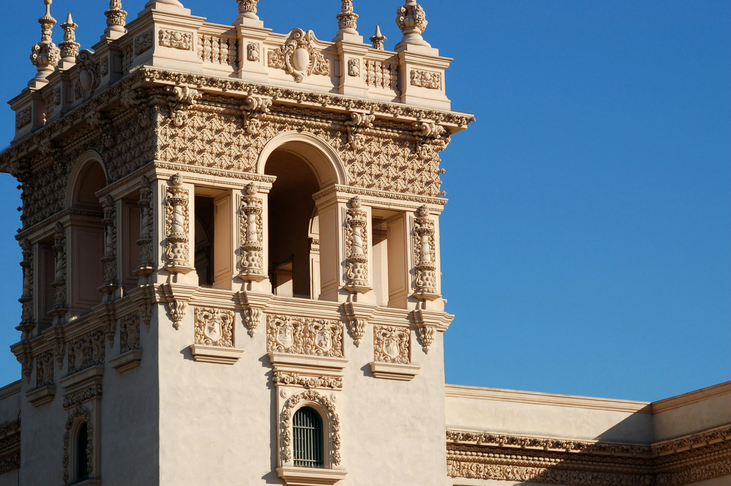an ornate clock tower on the side of a white building