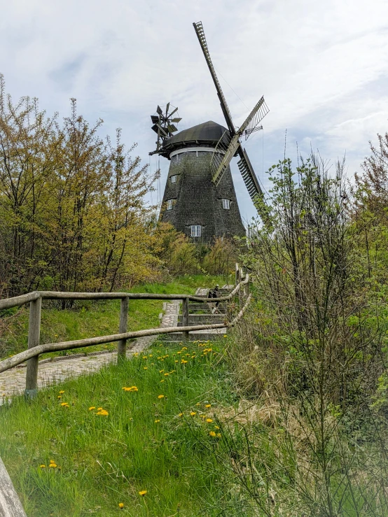 there is a windmill that stands in the grass
