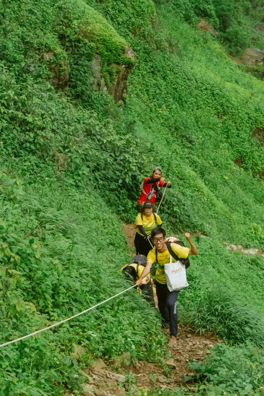 two people with backpacks are walking up a hill