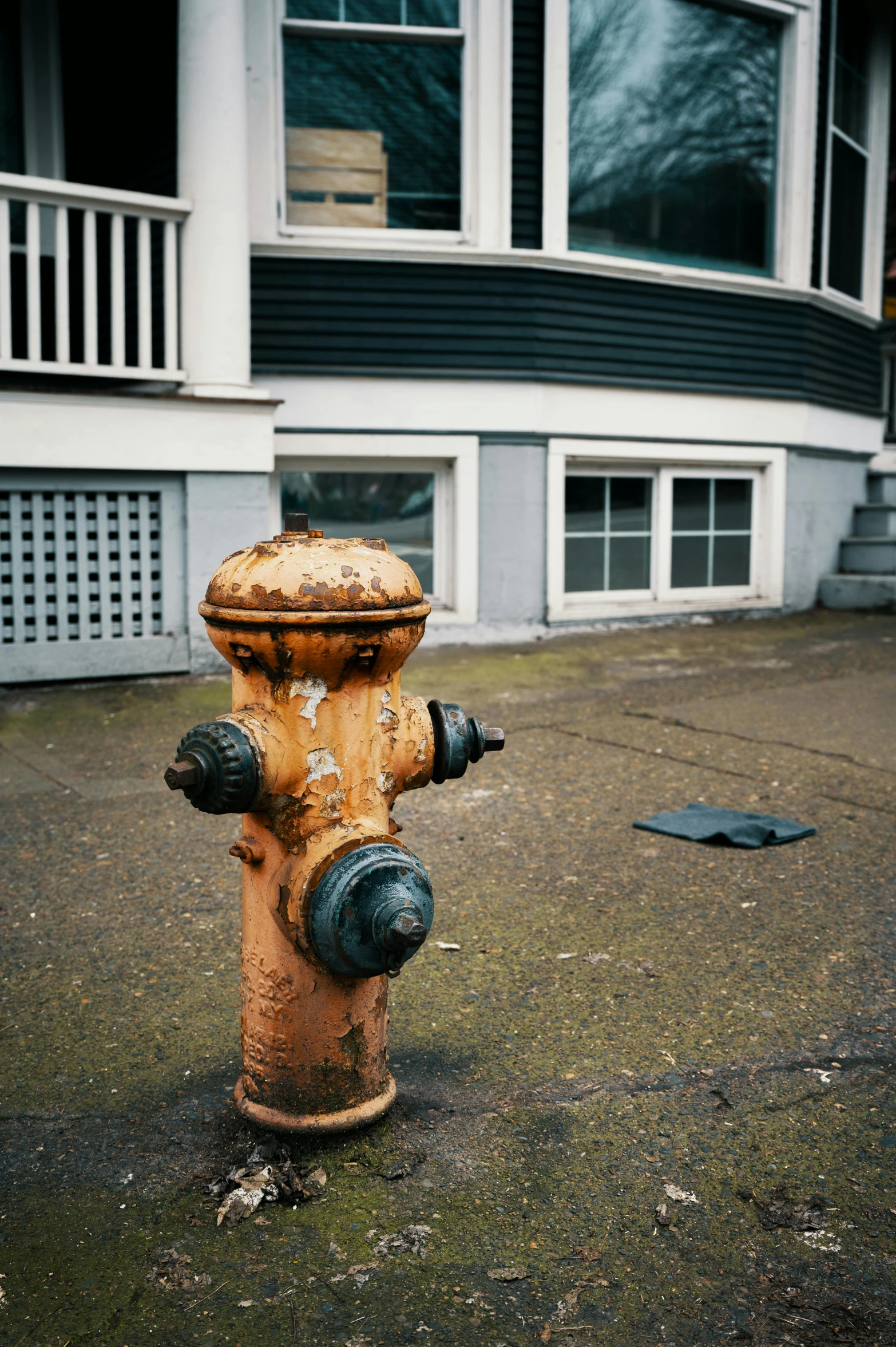 a rusted yellow fire hydrant sits on a sidewalk