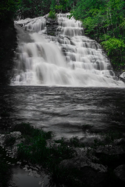 a large waterfall is shown in the middle of a forest