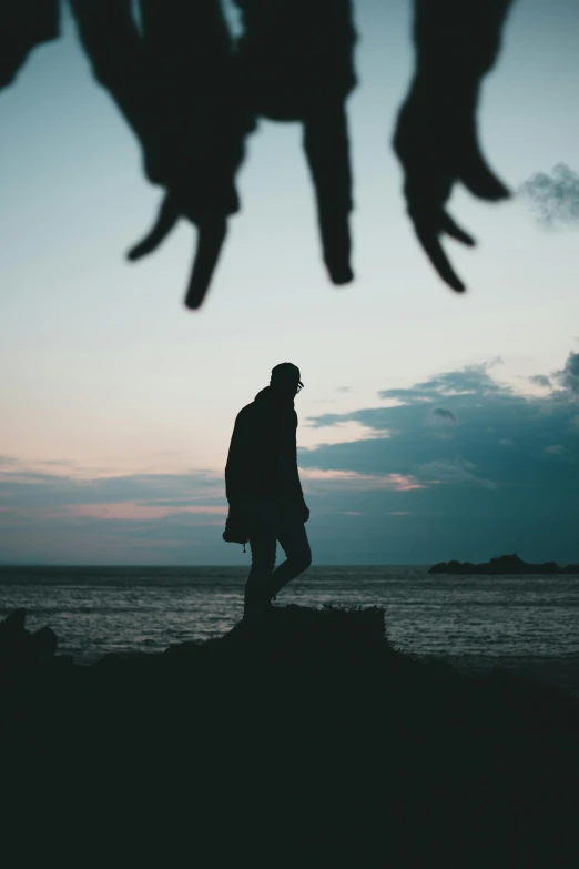 a person standing near the ocean looking at the sky