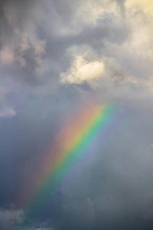 a rainbow appears in the sky above the clouds