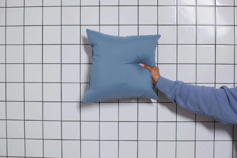 a person's hand holding onto the edge of a blue cushion
