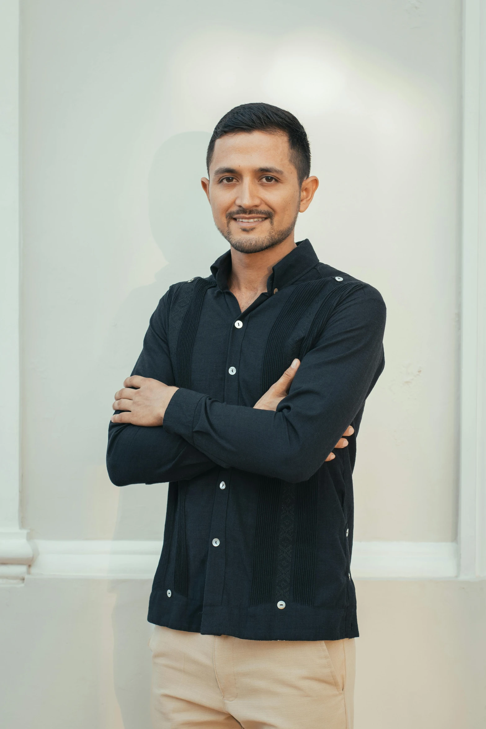 a man standing in front of a large white wall