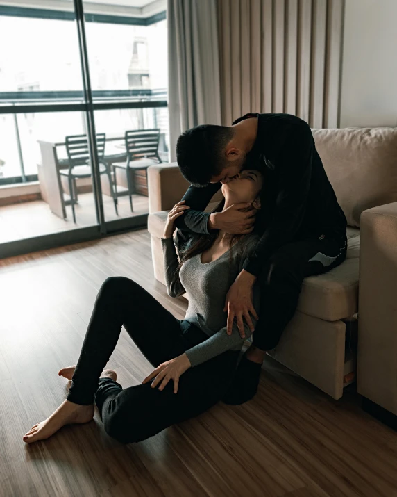 a man sitting on the floor with his arm around a woman