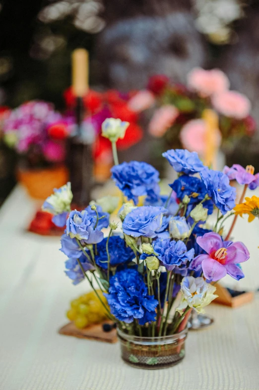 a table with several flowers in vases next to other flowers