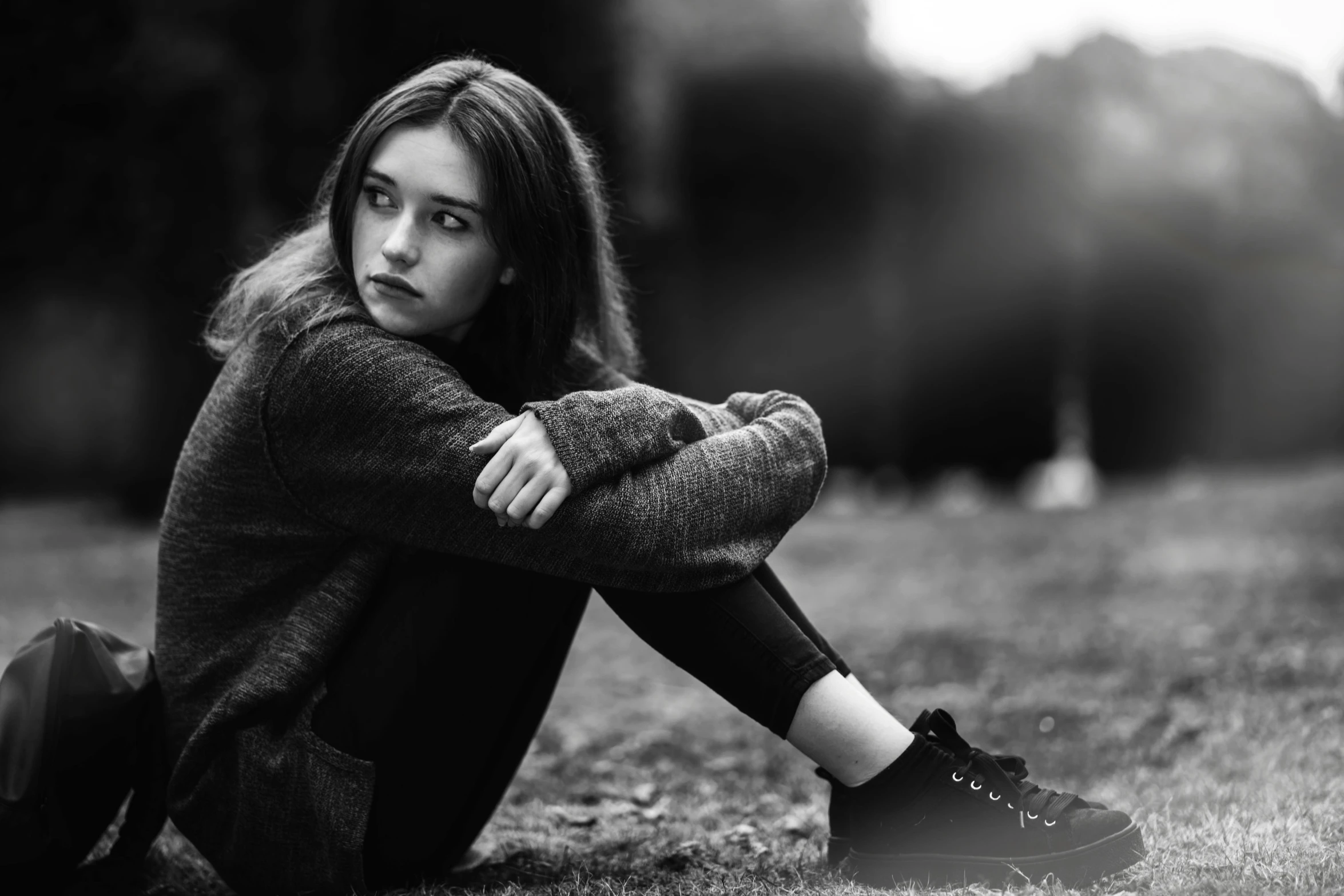 a woman sitting in the grass posing for a po