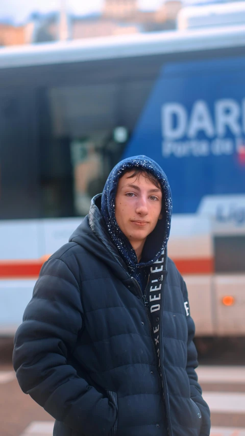 a man standing on the street next to a bus