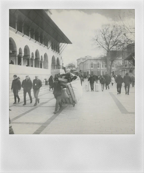 an old black and white pograph of people walking around