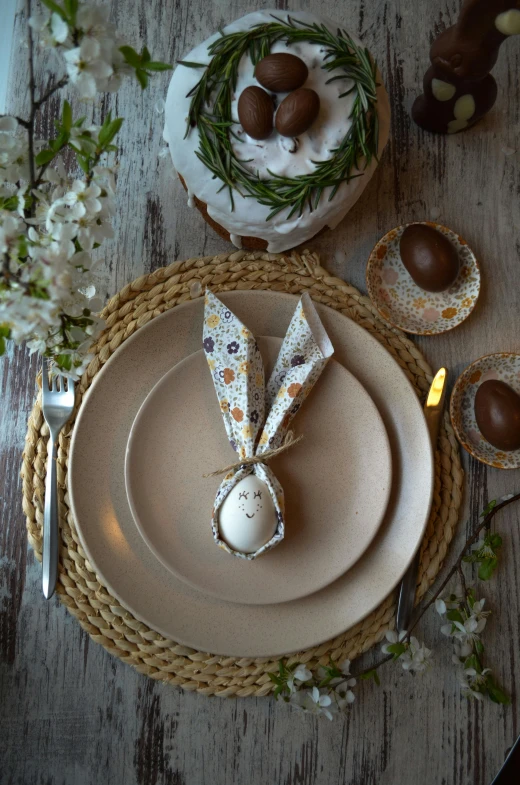 place settings for a dinner with brown and white napkins and flowers