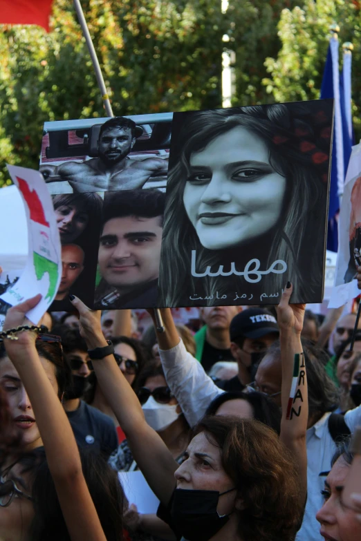 there are many people holding up pictures and a sign