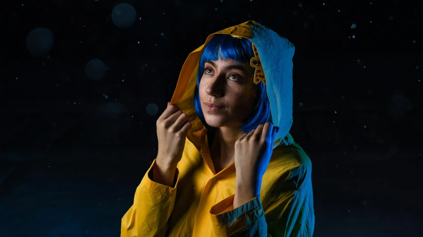 woman wearing yellow and blue raincoat and hood