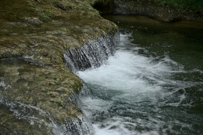 the water is running over the large rock