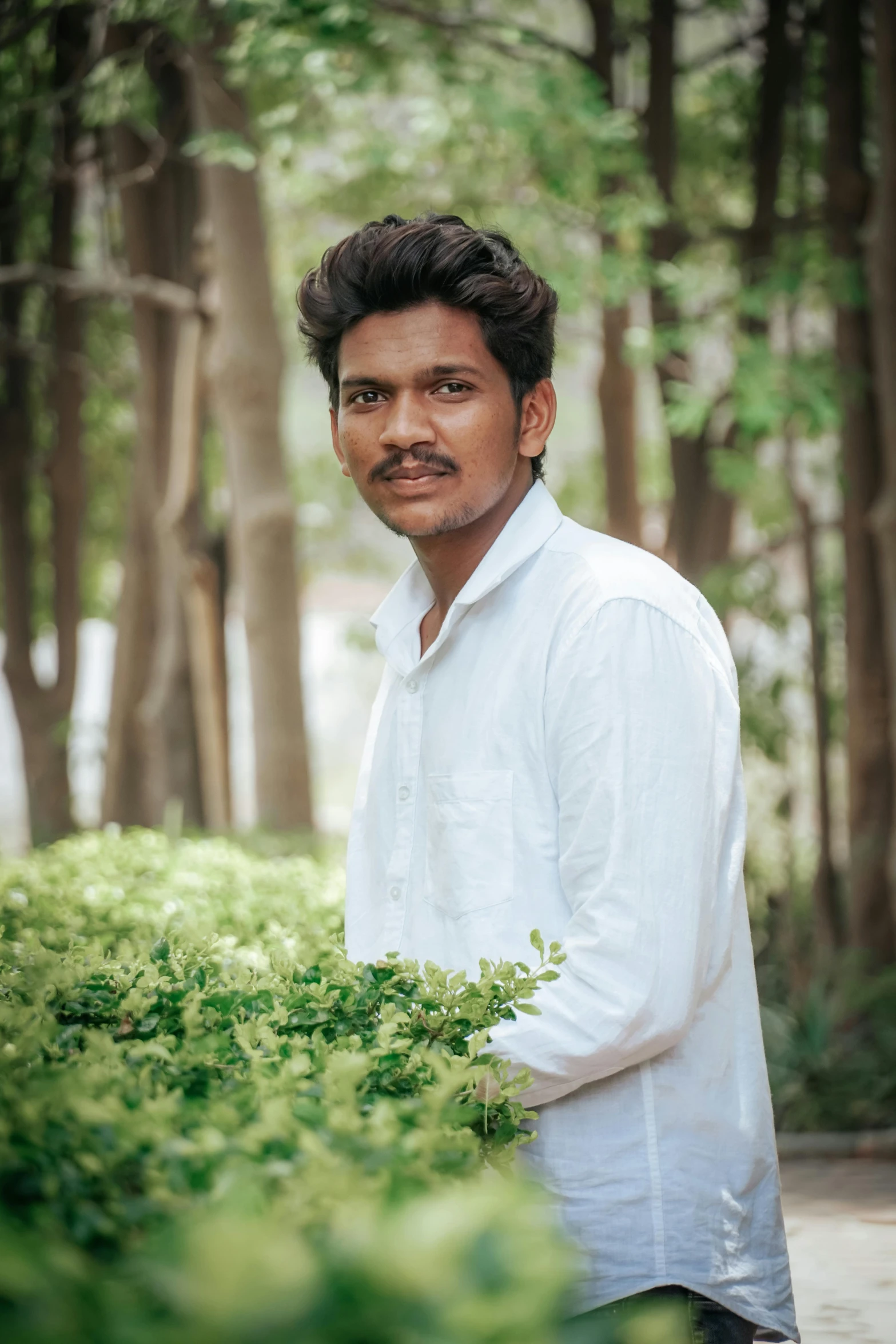 a man standing in front of trees in the forest