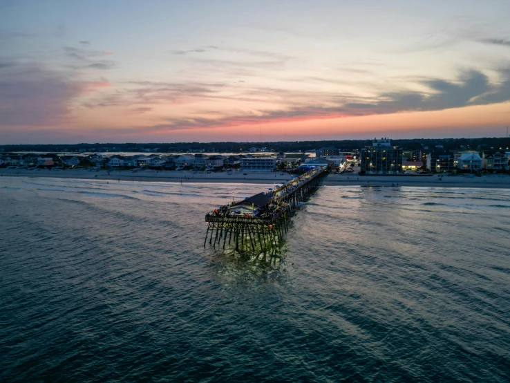 a pier is shown at dusk, with the sky painted blue