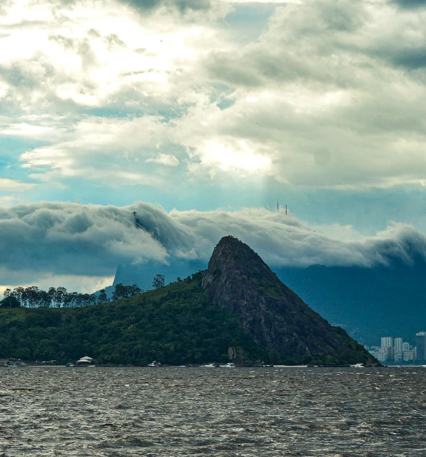 some clouds gather over a mountain and land