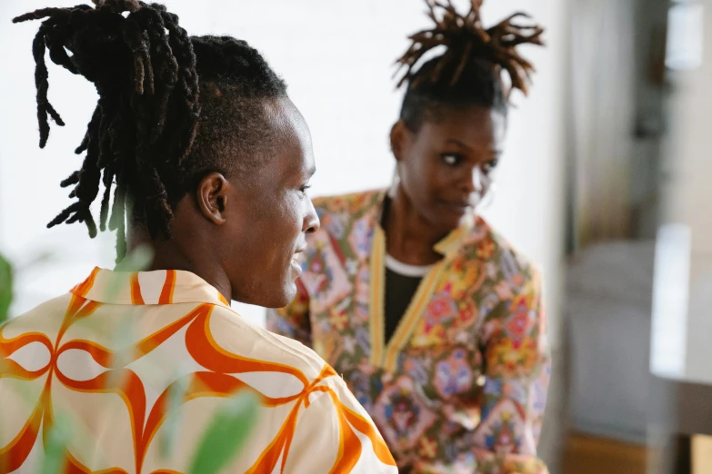 two women with dreadlocks stand around talking