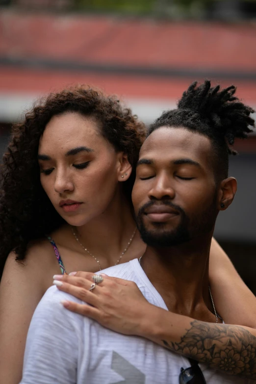 the woman is holding the man's back while he hugs his hand