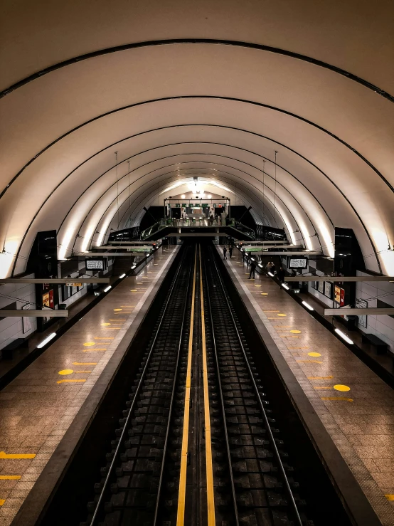 a train traveling down tracks under a tunnel