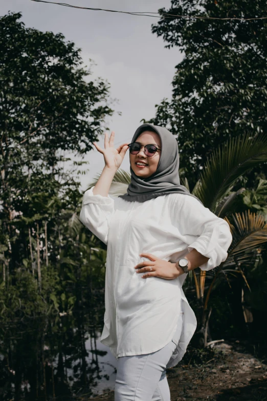 a woman standing in front of trees in her scarf