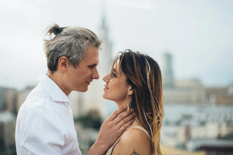 a beautiful woman hugging a man standing near water