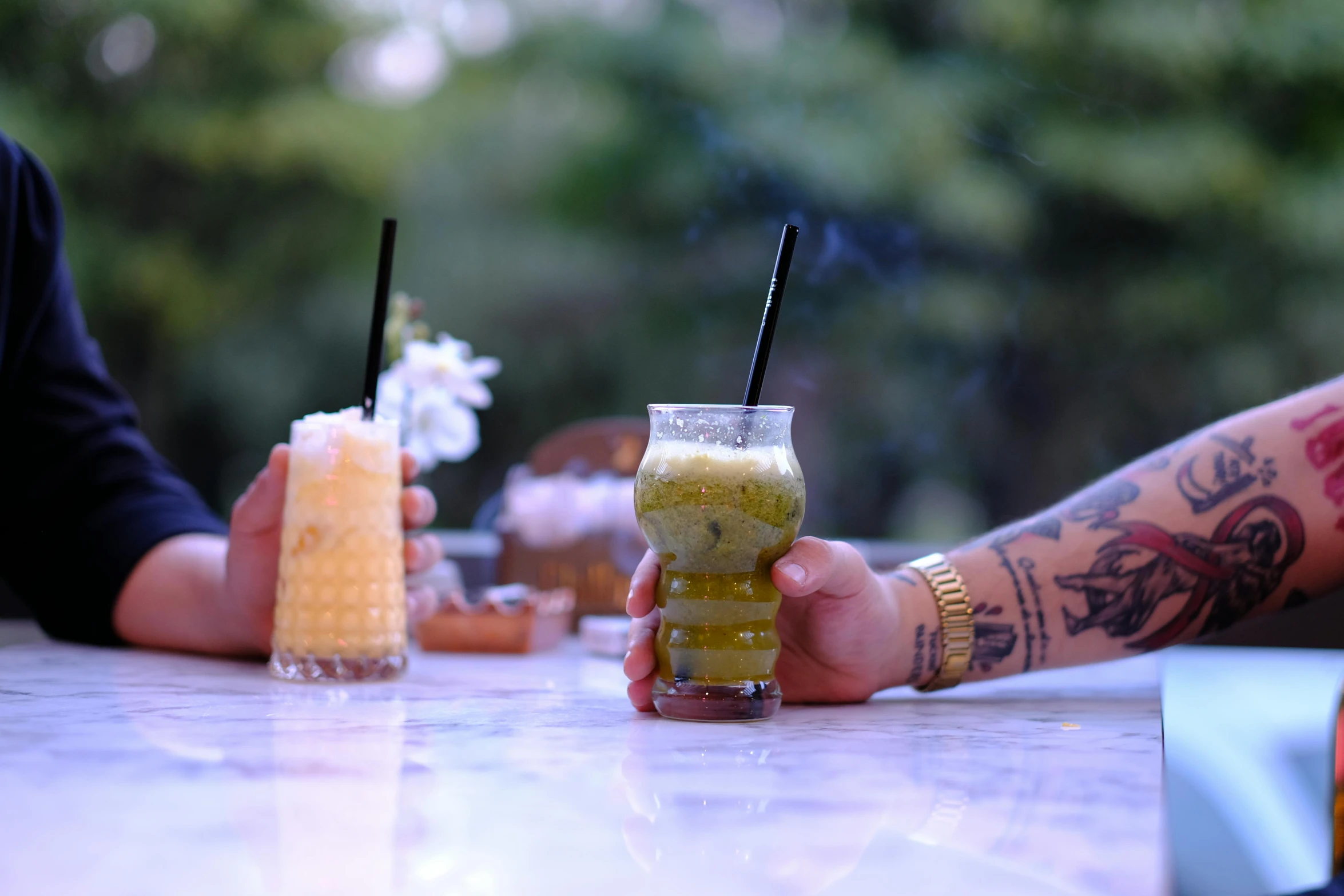 a couple of people are drinking drinks on a table