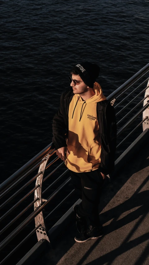 a man standing next to a metal railing near the water