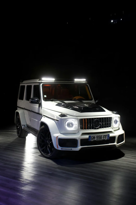 the front end of a white suv, with headlight on