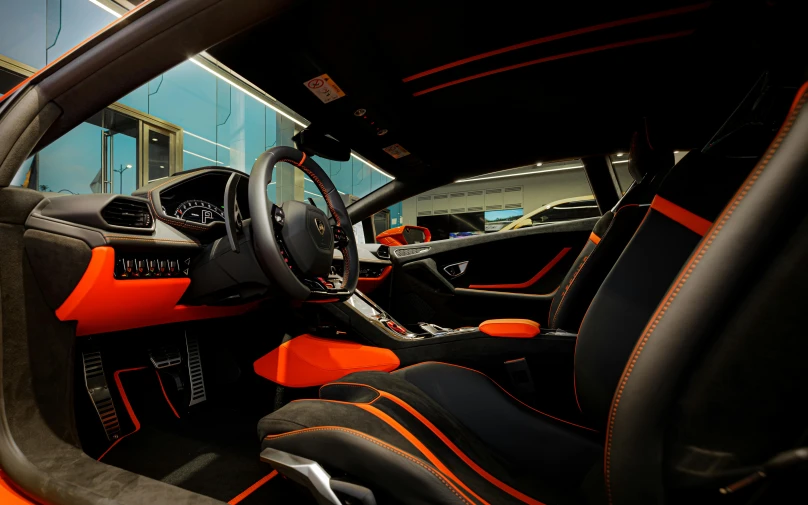 a black and orange sports car parked at a bus stop