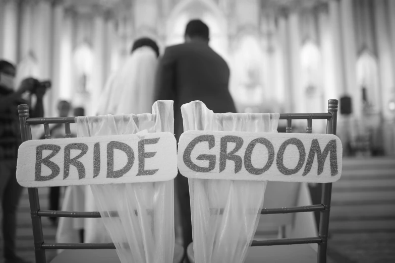 two wooden chairs with the words'bride and groom'on them