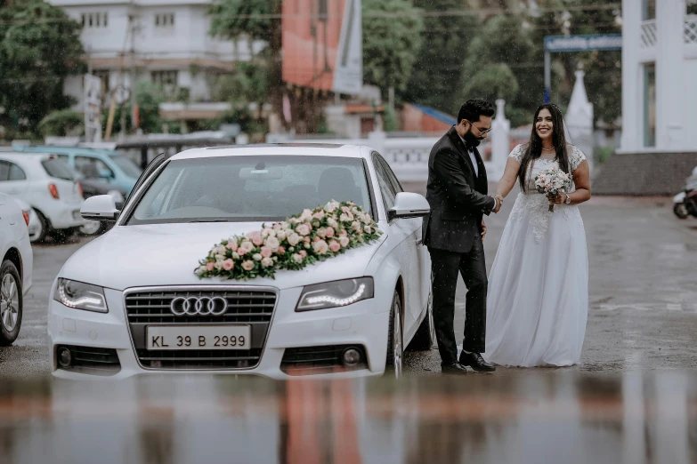 a man and woman standing next to a car