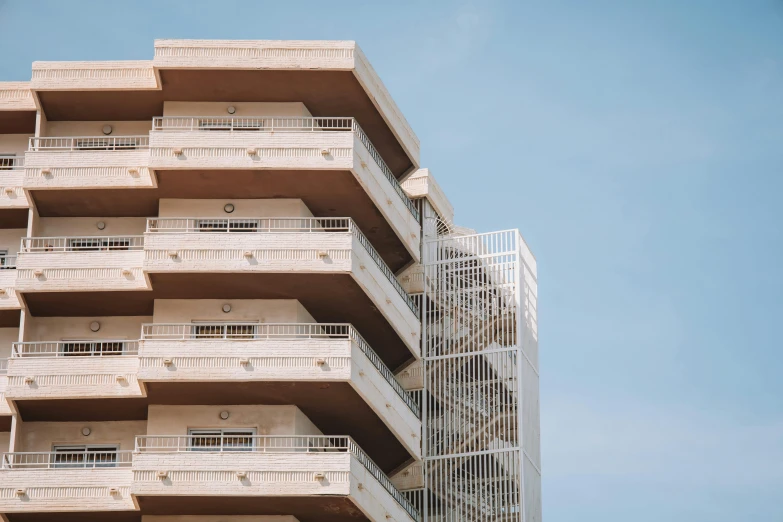 the top of a tall beige building with balconies on each