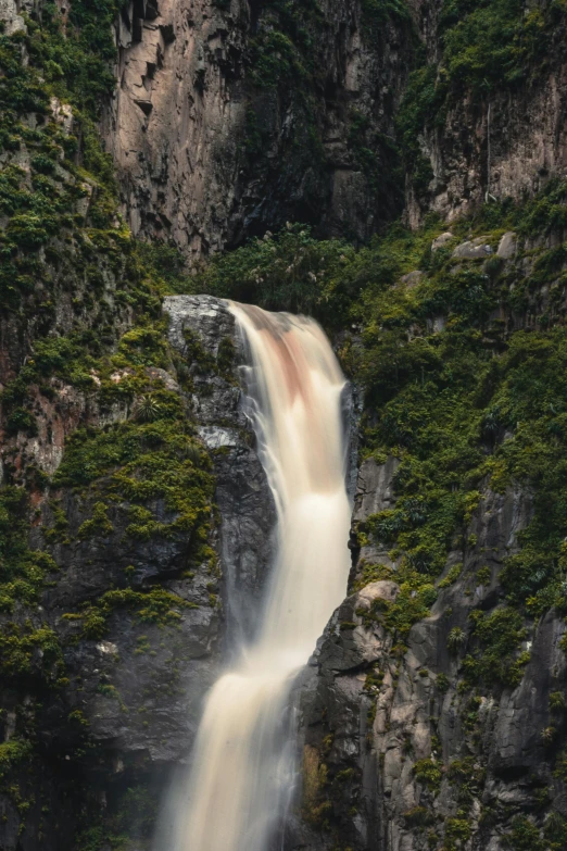 a close up image of a waterfall in the forest